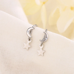 S925 silver star and moon drop earrings with micro-inlaid zircon on linen background