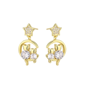 Détail de boucles d'oreilles chat et lune dorées avec cristaux sur fond blanc