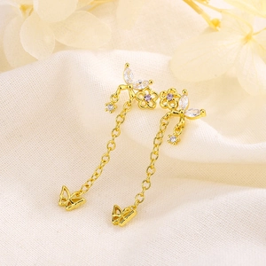 Boucles d'oreilles papillon dorées avec pompons et zirconiums sur tissu doux