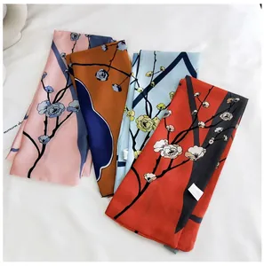 Détail de quatre foulards en satin de soie colorés avec des motifs floraux de prunier