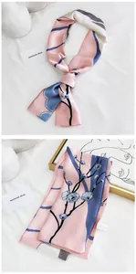 Détail d'un foulard étroit élégant rose et gris avec motif délicat de fleurs de prunier