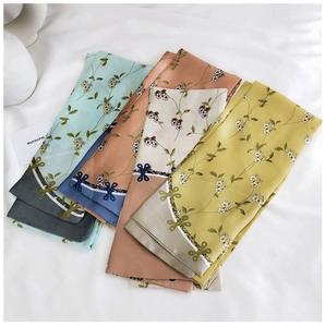 Lot de quatre écharpes étroites à fleurs en menthe, rose, blanc et jaune sur fond drapé