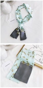 Gros plan sur l'écharpe étroite en soie bleue avec motif floral élégant et texture