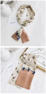 Vue détaillée d'un foulard étroit en soie avec imprimés floraux, nœuds bleus et patchwork