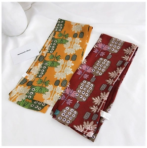 Détail de foulards étroits en soie aux motifs floraux vintage jaune et bordeaux