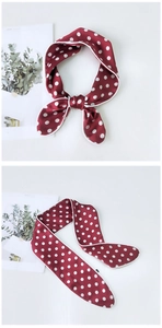 Close-up of red polka dot silk scarf showing refined stitching and satin texture