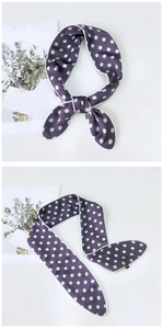 Detailed view of dark purple polka dot twilly scarf tied in a bow with white piping