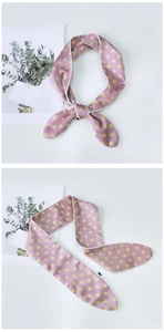 Detailed view of pink silk scarf with yellow polka dots and white stitched edges