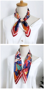 Detailed view of colorful silk scarf tied in elegant knots on a white shirt collar