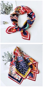 Close-up of vibrant floral print silk square scarf showing detailed stitching and fabric texture