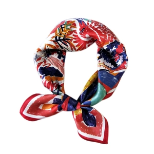 Silk square scarf with colorful abstract floral print and red border in a knotted style