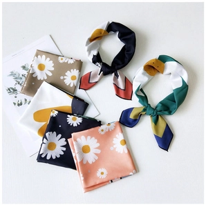 Close-up of floral satin square scarves folded into elegant decorative bow shapes