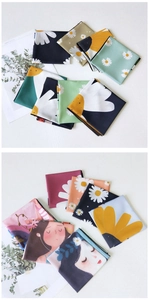 Close-up of assorted floral daisy and character print silk-like scarves in various colors