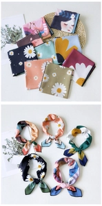 Macro detail of various floral silk scarves with daisy patterns and smooth satin texture