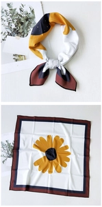 Detail of square silk scarf with yellow sunflower pattern and elegant border