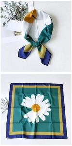 Detail of square silk scarf with dark green daisy print and colorful geometric borders
