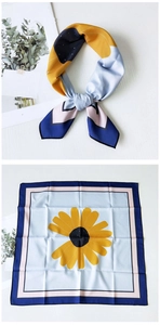 Detail view of square silk scarf featuring sunflower floral print and geometric borders