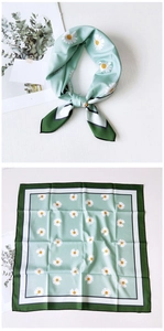 Close-up of mint green square silk scarf with daisy pattern and striped border edge