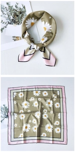 Detail of square silk scarf with white daisy print and olive green base and pink borders
