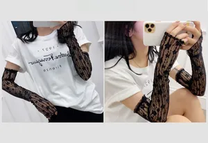 Detailed close-up of black lace arm sleeves with elegant floral embroidery and sheer texture