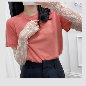 Detailed close-up of pink t-shirt paired with elegant white floral lace sleeve covers