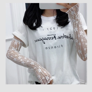 Detail view of floral white lace arm sleeves with delicate ruffled edges for sun protection