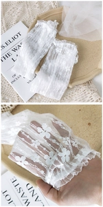 Detailed view of white floral lace arm sleeves with elegant ruffled edges for women