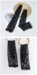 Macro detail of black floral lace arm sleeves with ruffled cuffs on wooden ring