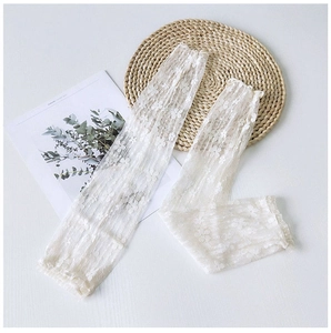 Detailed view of white floral lace arm sleeves with elegant translucent mesh texture