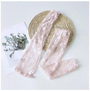 Detailed close-up of pink floral lace arm sleeves with elegant scalloped edges
