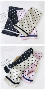 Detailed view of polka dot silk scarves in black, cream, and pink with premium texture