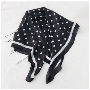Detail of lightweight polka dot silk scarf with elegant white border and soft texture