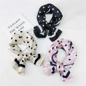 Three elegant polka dot silk square scarves in black, cream and pink with bow styling