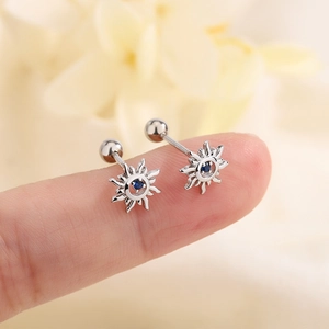 Silver sun flower stud earrings with blue gemstone and screw back ball shown on fingertip