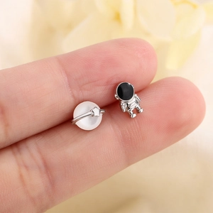 Asymmetric astronaut and planet stud earrings featuring silver metal and opal-style beads