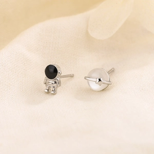 Asymmetric astronaut and planet stud earrings set with silver metallic finish