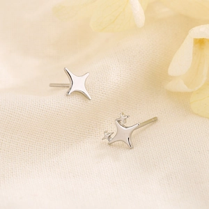 Asymmetric silver four-pointed star earrings in minimalist stainless steel jewelry design