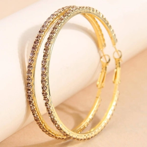 Detailed view of 6cm gold hoop earrings with sparkling rhinestones in a luxury close-up