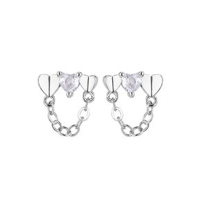 Close-up of heart-shaped silver earrings with sparkling zircon and delicate tassel chains