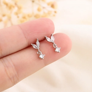 Elegant silver leaf drop earrings with marquise-cut stones shown on a finger