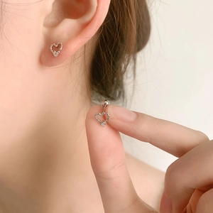 S925 silver hollow heart stud earrings with small zircon stone shown on the earlobe
