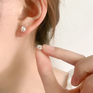 Boucles d'oreilles fleurs délicates en argent 925 avec fermoir à vis sur un mannequin