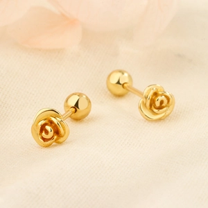 Detail shot of golden rose earrings featuring 3D layered petals and a secure screw back