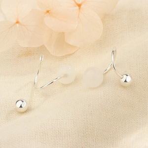 Gros plan de boucles d'oreilles en argent S925 avec perles blanches et fermoir vis