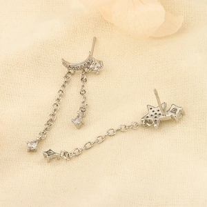 925 silver moon and star tassel earrings with white zircon on beige fabric background