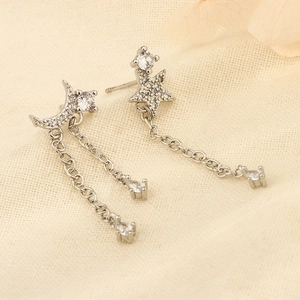 Detailed macro view of 925 sterling silver moon and star tassel earrings with white zircons