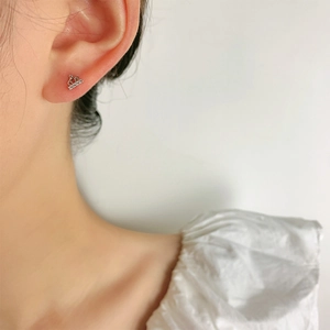 Élégante boucle d'oreille couronne en argent 925 avec cristaux sur un mannequin femme