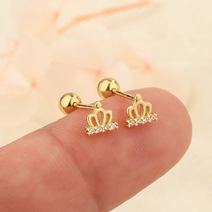 Boucles d'oreilles couronne dorée avec zircons et fermoir à vis sur le bout du doigt