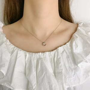 Collier élégant avec pendentif étoile et lune argenté sur une fine chaîne de clavicule