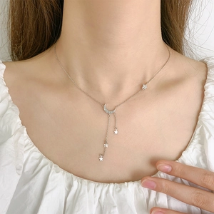 Elegant star and moon tassel necklace featuring crystal charms on a silver-tone chain